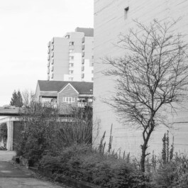 Bunkerwand neben Wohnhäusern mit Hochhaus im Hintergrund, in Hannover 