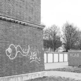 Graffiti auf Ziegelwand eines Bunkers neben Garagenhof 